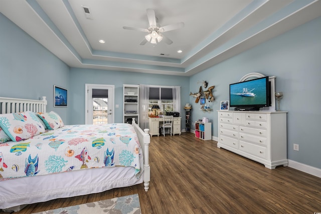 bedroom featuring ceiling fan, dark hardwood / wood-style flooring, and a raised ceiling