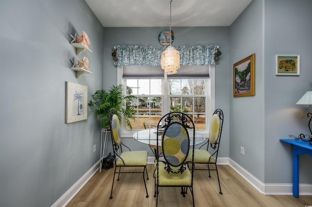 dining area featuring light wood-type flooring and an inviting chandelier