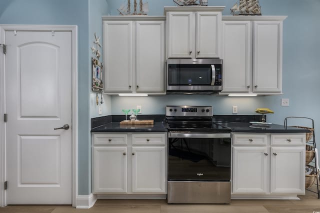 kitchen featuring white cabinets, appliances with stainless steel finishes, and light hardwood / wood-style flooring