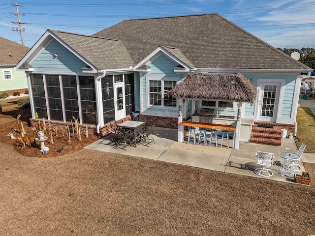 back of property featuring a bar, a patio, area for grilling, and a sunroom