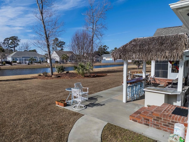 view of patio / terrace featuring a water view and exterior bar