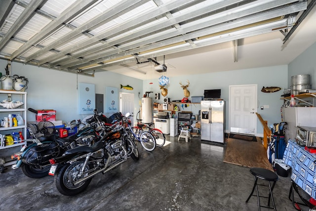 garage featuring gas water heater, stainless steel refrigerator with ice dispenser, and a garage door opener