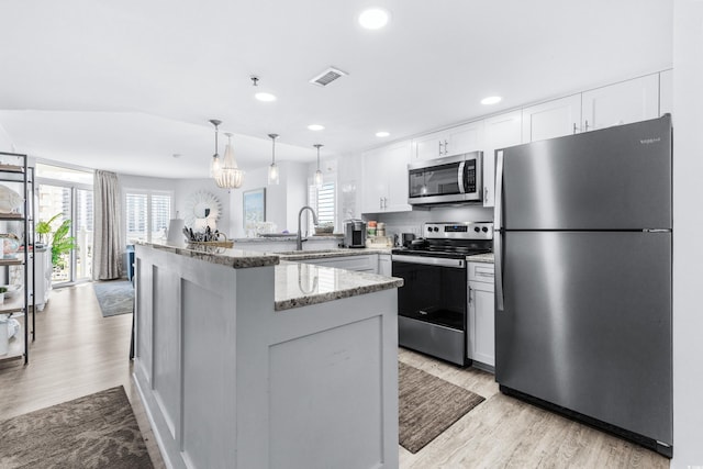 kitchen with white cabinetry, sink, light stone countertops, and appliances with stainless steel finishes