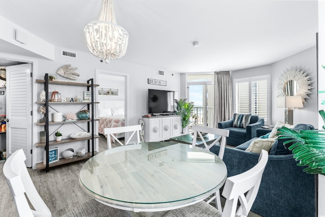 dining room with hardwood / wood-style floors and a notable chandelier