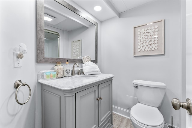 bathroom with hardwood / wood-style floors, vanity, and toilet