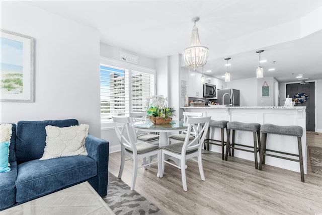 dining room featuring light hardwood / wood-style flooring and a notable chandelier