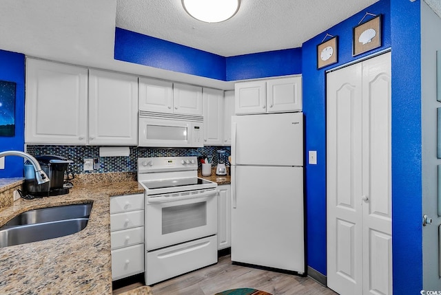 kitchen featuring white cabinetry, white appliances, and decorative backsplash