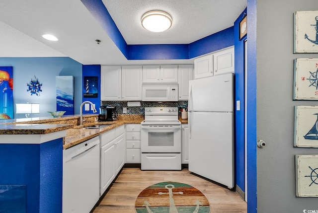 kitchen featuring white cabinetry, sink, white appliances, kitchen peninsula, and a textured ceiling