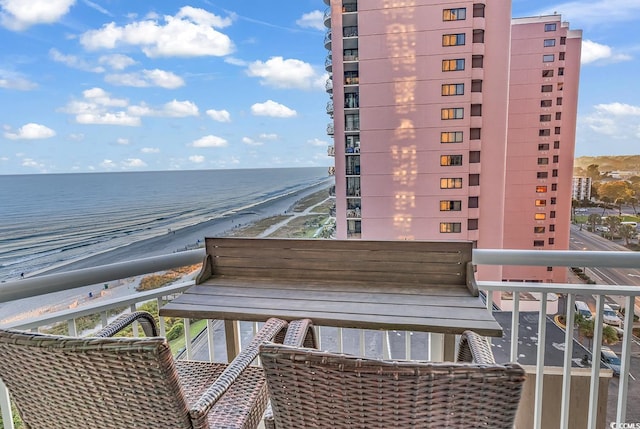 balcony featuring a view of the beach and a water view