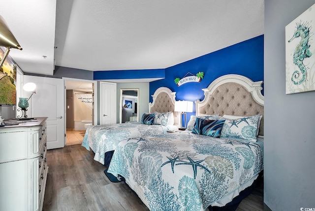 bedroom with hardwood / wood-style flooring and ensuite bathroom