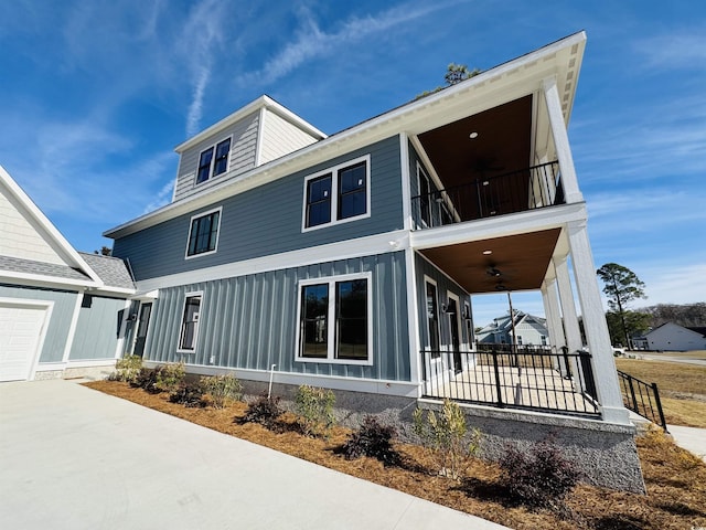 view of front facade with ceiling fan, a garage, and a balcony