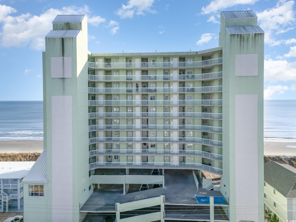 view of property featuring a water view and a beach view