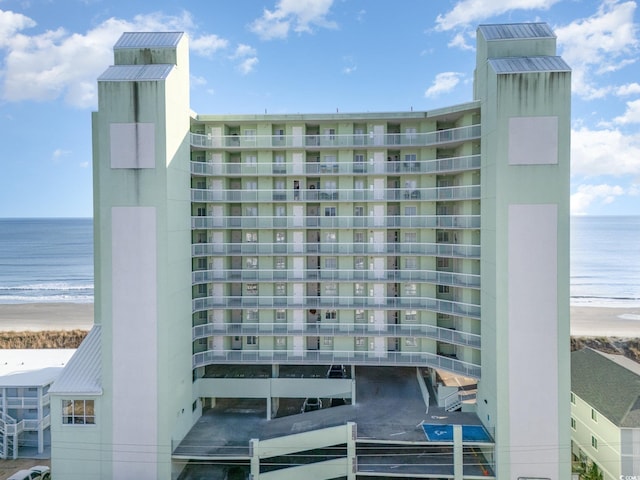 view of property featuring a water view and a beach view