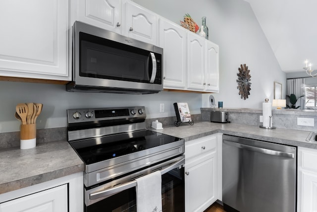 kitchen featuring white cabinets, stainless steel appliances, and lofted ceiling