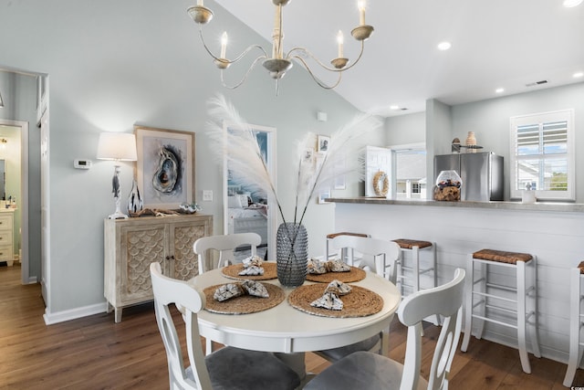 dining space featuring lofted ceiling, an inviting chandelier, and dark wood-type flooring