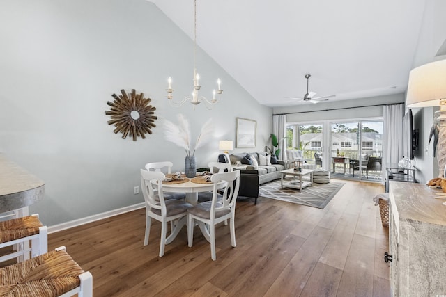 dining area featuring lofted ceiling, wood-type flooring, and ceiling fan with notable chandelier