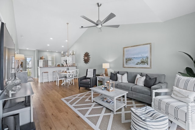 living room featuring ceiling fan, high vaulted ceiling, and light wood-type flooring