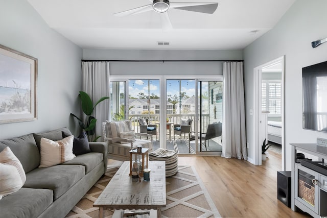 living room featuring light wood-type flooring and ceiling fan