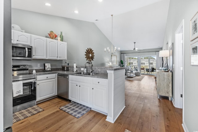 kitchen featuring sink, stainless steel appliances, light hardwood / wood-style flooring, kitchen peninsula, and white cabinets