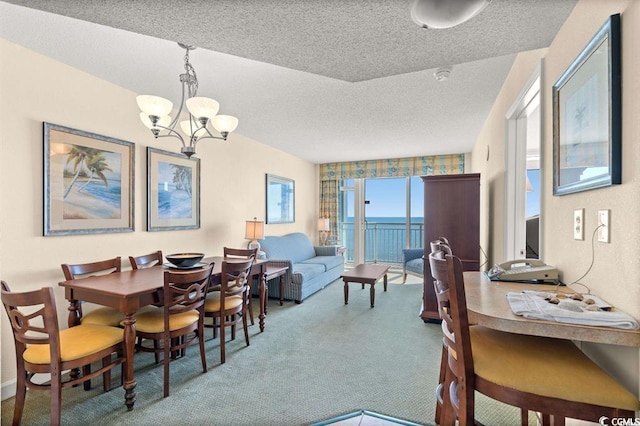 dining room with a textured ceiling, a chandelier, and carpet floors