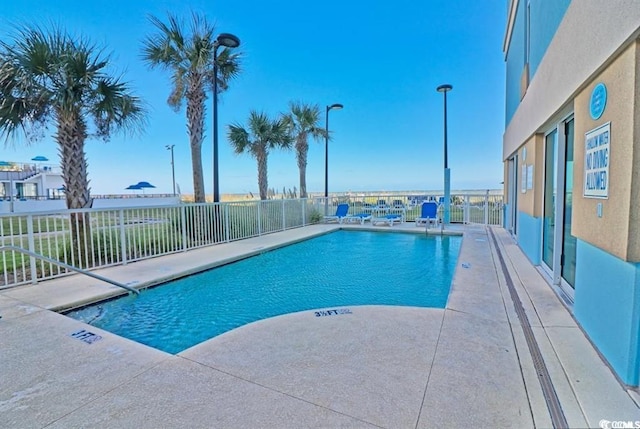 community pool with fence and a patio