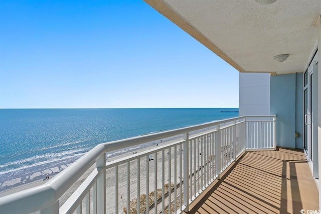 balcony with view of water and beach