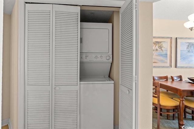 washroom with stacked washing machine and dryer