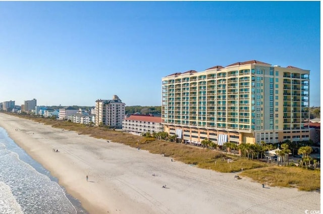 view of building exterior with a beach view and a water view