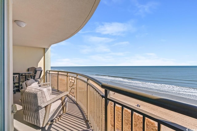 balcony featuring a water view and a view of the beach