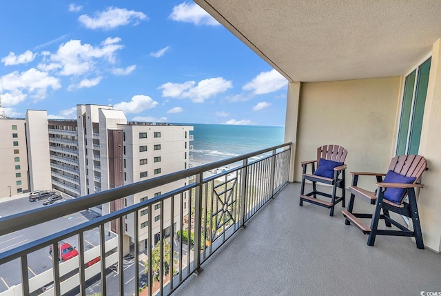 balcony with a beach view and a water view