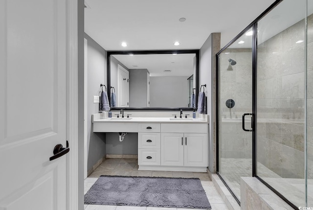 bathroom with tile patterned flooring, vanity, and walk in shower