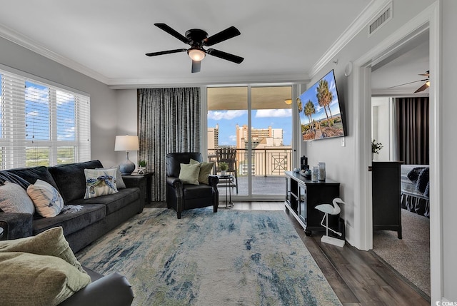 living room with ceiling fan, crown molding, and dark wood-type flooring