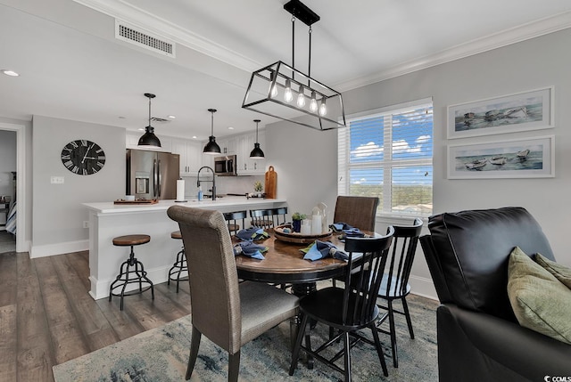 dining space with crown molding and dark wood-type flooring