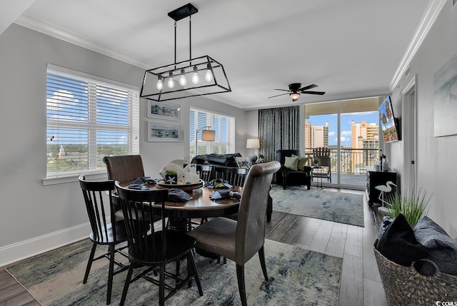 dining room with ceiling fan, crown molding, and wood-type flooring