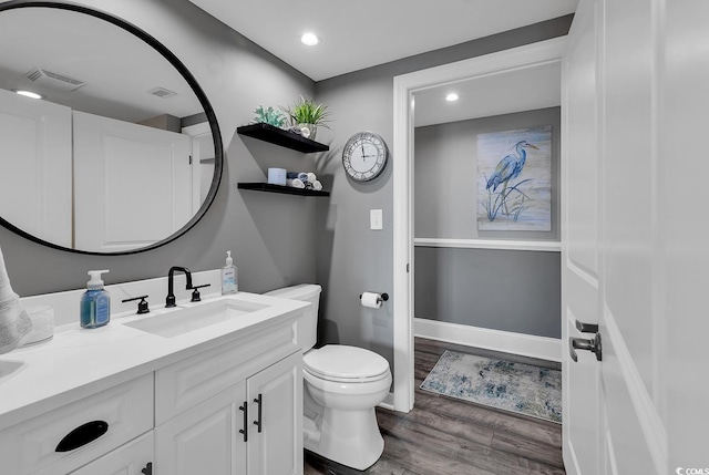 bathroom with wood-type flooring, vanity, and toilet