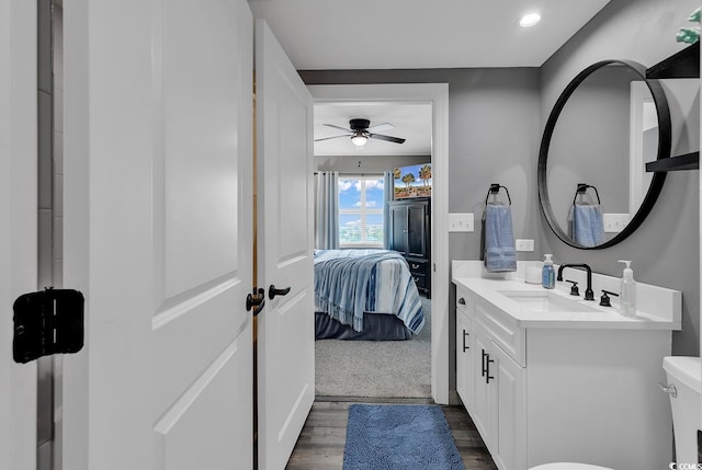 bathroom featuring hardwood / wood-style floors, vanity, toilet, and ceiling fan