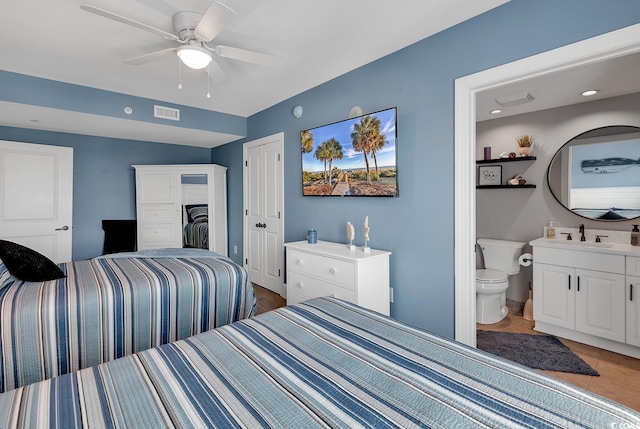 tiled bedroom with a closet, connected bathroom, ceiling fan, and sink