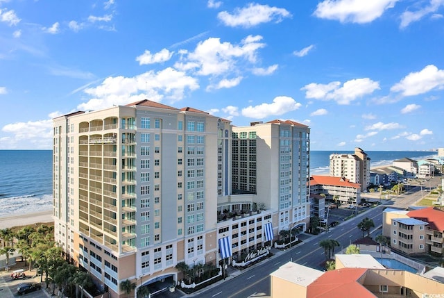 view of building exterior with a water view and a view of the beach