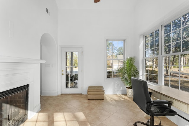 unfurnished office featuring light tile patterned floors and a towering ceiling