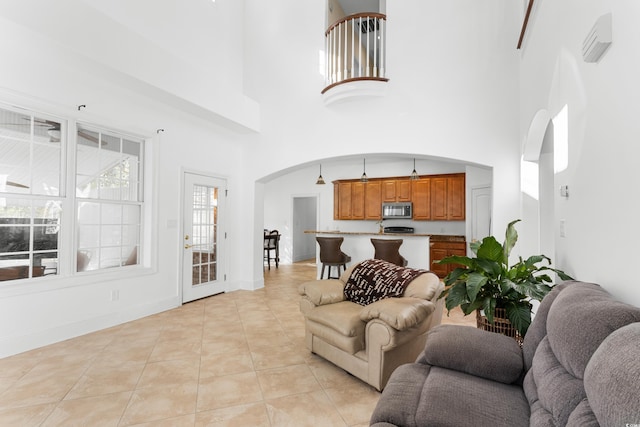 living room with light tile patterned floors and a high ceiling