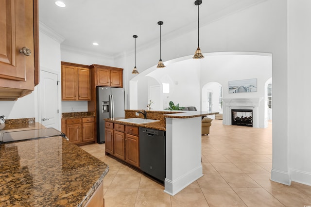 kitchen with pendant lighting, dishwasher, a multi sided fireplace, sink, and stainless steel fridge