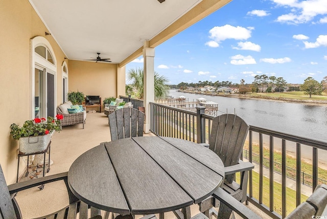 balcony featuring a water view and ceiling fan