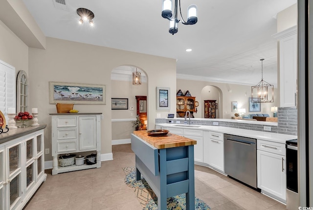 kitchen with white cabinetry, sink, stainless steel appliances, wooden counters, and a kitchen island