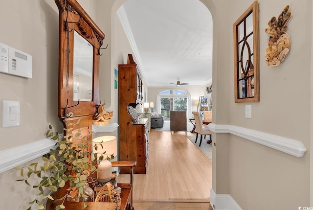 hallway featuring light wood-type flooring and ornamental molding