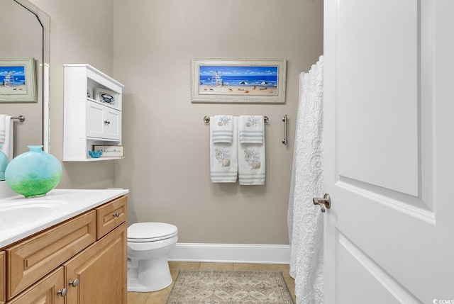 bathroom featuring tile patterned floors, vanity, and toilet