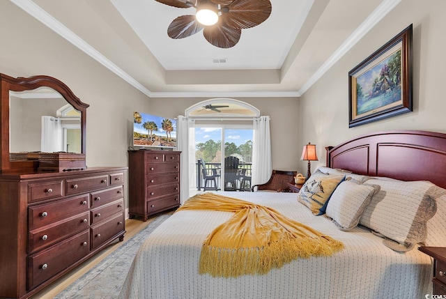 bedroom featuring access to exterior, a raised ceiling, ceiling fan, crown molding, and light hardwood / wood-style floors