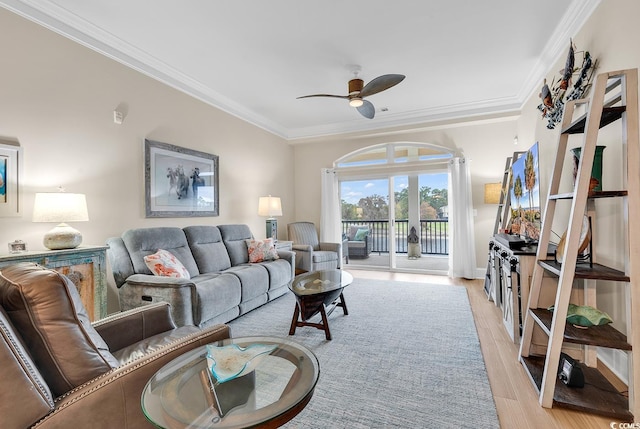 living room with ceiling fan, ornamental molding, and light wood-type flooring