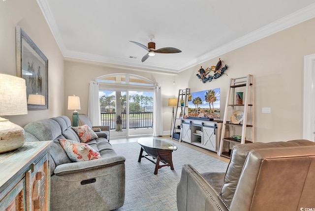 living room featuring ceiling fan, crown molding, and light hardwood / wood-style flooring