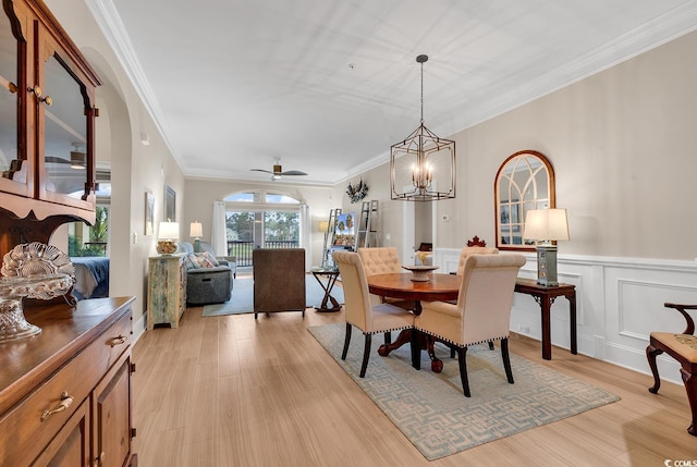 dining area featuring ceiling fan with notable chandelier, light hardwood / wood-style floors, and ornamental molding