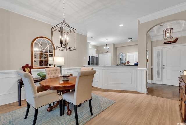 dining space featuring light wood-type flooring and ornamental molding